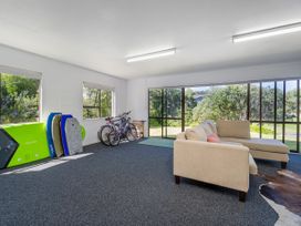 A snug with bicycles and bodyboards at Whangapoua
