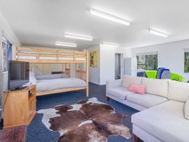 A bedroom with bunk bed and sofa at Whangapoua