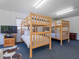 A bedroom with bunk beds and a television at Whangapoua