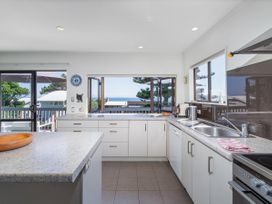 A kitchen with a sink and stove at Whangapoua