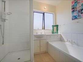 A bathroom with a shower and bathtub at Whangapoua
