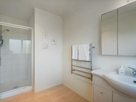 A bathroom with a shower and sink at Whangapoua