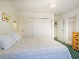 A bedroom with a bed and wardrobe at Whangapoua in Whangapoua