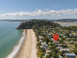 An aerial view of a beach and residential area at Whangapoua in Whangapoua