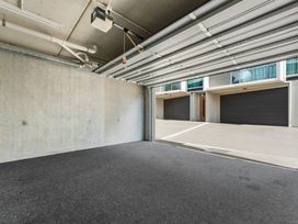 A garage with a garage door and concrete walls at Lake Taupo Holiday Home in Taupo