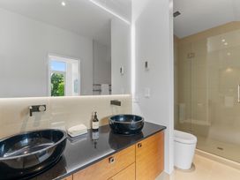 A bathroom with sinks and a shower at Lake Taupo Holiday Home in Taupo