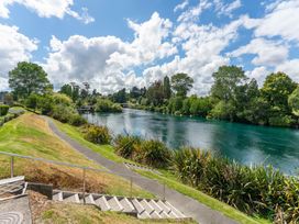 A river with trees and a path at Lake Taupo Holiday Home in Taupo