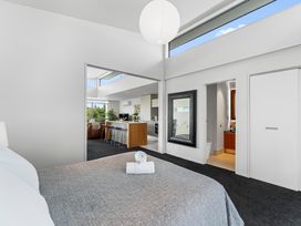 A bedroom with a bed and a door to a kitchen at Lake Taupo Holiday Home in Taupo