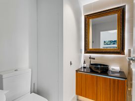 A bathroom with a toilet, sink, and mirror at Lake Taupo Holiday Home in Taupo