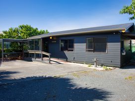 An outdoor area with a house and seating at The Bach - Kaikoura Holiday Home Kaikoura