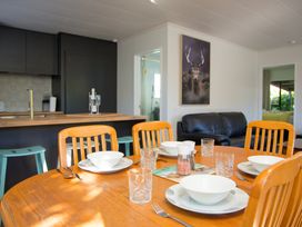 A dining room with a table set for meal at The Bach - Kaikoura Holiday Home Kaikoura