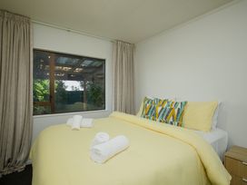 A bedroom with a bed and window at The Bach - Kaikoura Holiday Home in Kaikoura