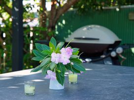 An outdoor table with a floral arrangement and a grill at The Bach - Kaikoura Holiday Home, Kaikoura