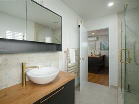 A bathroom with a wash basin and mirror at The Bach - Kaikoura Holiday Home in Kaikoura