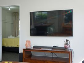 A living room with a television on a stand at The Bach - Kaikoura Holiday Home, Kaikoura