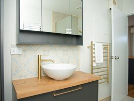 A bathroom with a wash basin and towel rack at The Bach - Kaikoura Holiday Home in Kaikoura
