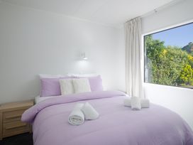 A bedroom with a bed and bedside table at The Bach - Kaikoura Holiday Home Kaikoura