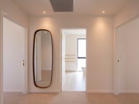 A hallway with a mirror and doors at Sunderland Views - Clyde Holiday Home Clyde