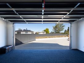 A garage with a rolling door and storage boxes at Sunderland Views - Clyde Holiday Home, Clyde