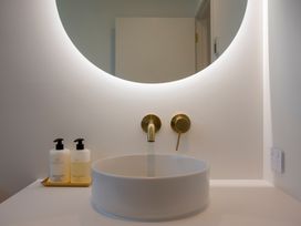 A sink with a round mirror and soap dispensers at Sunderland Views - Clyde Holiday Home Clyde