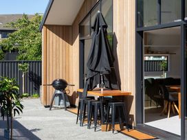 An outdoor seating area with a table and stools at Sunderland Views - Clyde Holiday Home, Clyde