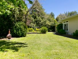 A garden area with a chiminea and greenery at The Trout House - Turangi Holiday Home Turangi