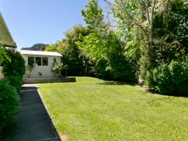 A garden with grass and trees at The Trout House - Turangi Holiday Home Turangi