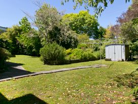 A garden with a shed and clothesline at The Trout House - Turangi Holiday Home in Turangi