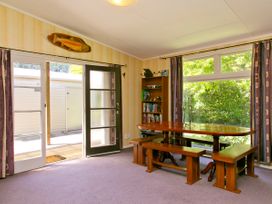 A dining room with a table and benches at The Trout House - Turangi Holiday Home, Turangi