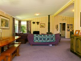 A living room with a sofa and dining table at The Trout House - Turangi Holiday Home, Turangi