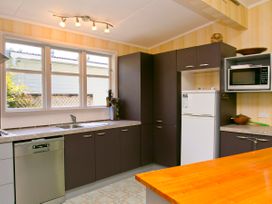 A kitchen with a sink, refrigerator, and microwave at The Trout House - Turangi Holiday Home in Turangi
