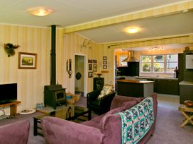 A living room with a television and fireplace at The Trout House - Turangi Holiday Home in Turangi