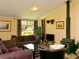 A living room with a sofa and television at The Trout House - Turangi Holiday Home Turangi