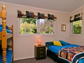 A bedroom with a bunk bed and a double bed at The Trout House - Turangi Holiday Home in Turangi