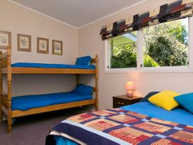 A bedroom with a bunk bed and a double bed at The Trout House - Turangi Holiday Home Turangi