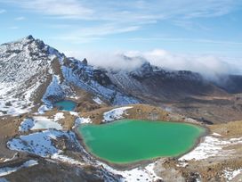 A landscape featuring lakes and snow capped mountains at The Trout House - Turangi Holiday Home Turangi