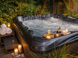 A hot tub with towels and champagne at The Trout House - Turangi Holiday Home in Turangi