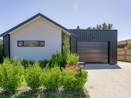 A house with a garage and front yard at Northlake Hideaway - Wanaka in Wanaka
