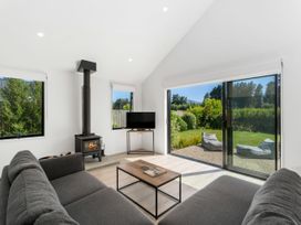 A living room with a wood stove and television at Northlake Hideaway - Wanaka Holiday Home Wanaka
