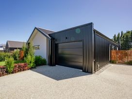 A house with a garage and garden at Northlake Hideaway - Wanaka Holiday Home Wanaka