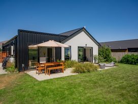 A house with outdoor seating and table at Northlake Hideaway - Wanaka Holiday Home, Wanaka