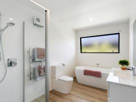 A bathroom with a shower, bathtub, and toilet at Northlake Hideaway - Wanaka Holiday Home, Wanaka