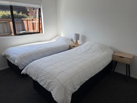 A bedroom with two beds and a nightstand at Northlake Hideaway - Wanaka Holiday Home Wanaka