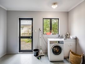 A laundry room with a washing machine and sink at Napier Holiday Home in Napier