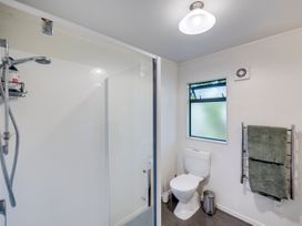 A bathroom with a shower, toilet, and towel rack at Napier Holiday Home, Napier
