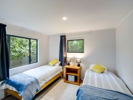A bedroom with two beds and a bedside table at Napier Holiday Home in Napier