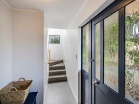 A hallway with stairs and a basket at Napier Holiday Home in Napier