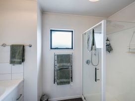 A bathroom with a shower and towels at Napier Holiday Home in Napier