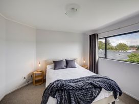 A bedroom with a bed and a window at Napier Holiday Home in Napier