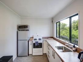 A kitchen with a refrigerator, oven, sink and microwave at Napier Holiday Home in Napier